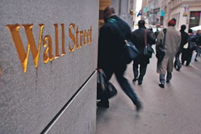 Image of people walking next to sign that says Wall Street