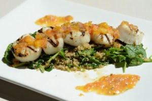 Grilled scallops with tarragon-citrus butter, baby spinach, toasted quinoa