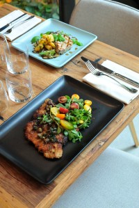 Pork chop Milanese with tomato, capers and arugula salad