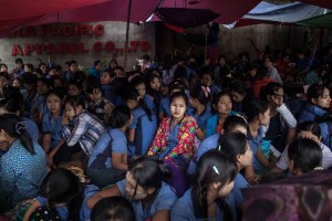 Factory workers sit in protest outside of the Nadia Pacific Apparel Co. Ltd