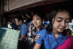 Factory workers listen to their Union Leader speak on October 13, 2015. On August 29 2015, the government of Myanmar announced a minimum wage of 3,600 kyats (about 3 US$). This slight pay raise was met with hostilities by factory owners in the Garment Industries who either refused to increase pay at all, made layoffs to keep expenses the same or cut overtime pay and benefits. Even those garment factory workers who have seen a increase in their daily wages have seen very little change in their salaries overall.