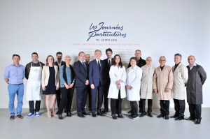 Antoine and Bernard Arnault posing with the group of artisans