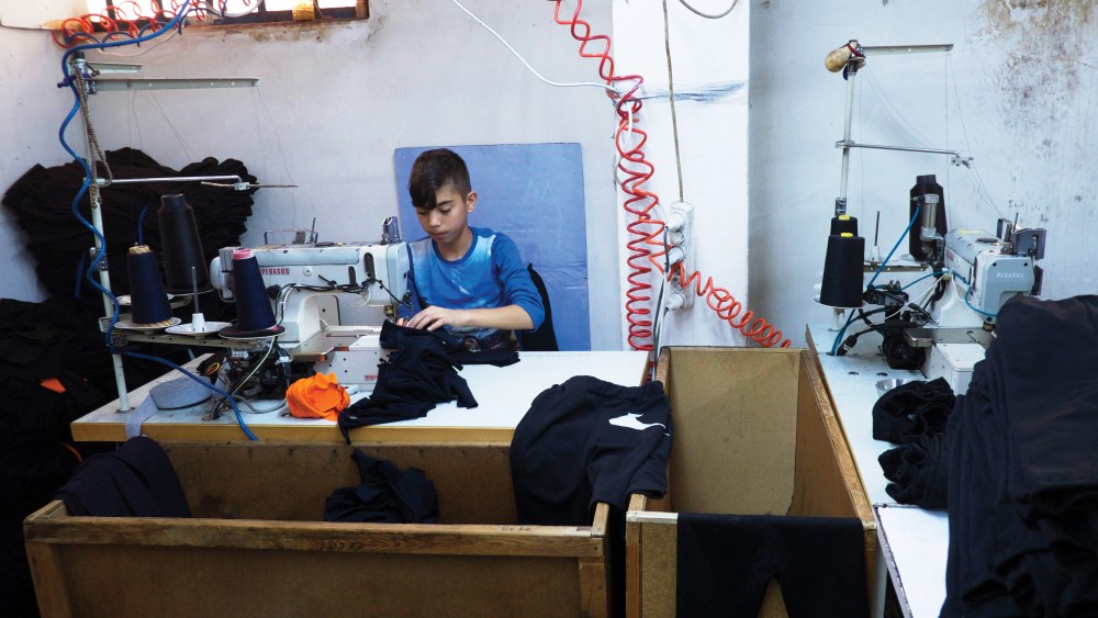 Up to 500,000 refugees could be working in the Turkish apparel industry, and many of them are children, like the one seen here.