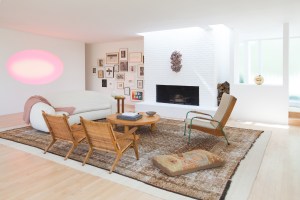 A house, designed by Courtney Applebaum, filled with contemporary art and midcentury furnishings begins with a living room featuring an ever-changing Elliptical Wide Glass piece by James Turrell and a wall-mounted shelf sculpture by Haim Steinbach. Armchairs by Jean Prouvé and Hans Wegner with a coveted vintage “patina,” combined with occasional tables by Charlotte Perriand and a Jean Royère–inspired sofa sit atop antique rugs.