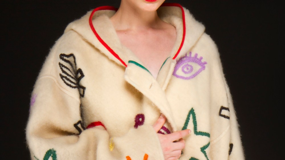 Jean-Charles de Castelbajac's beige wool coat with multicolored patterns, red interior and hood for fall-winter 1988.