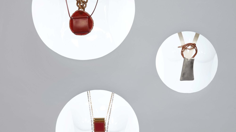 Loewe’s brass and leather jewelry bag necklace. Valentino's brass lipstick case necklace. Givenchy’s leather pouch and agate stone, brass and plastic necklace.