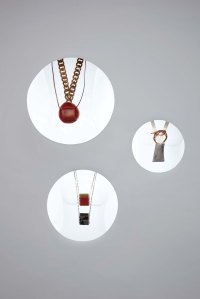 Loewe’s brass and leather jewelry bag necklace. Valentino's brass lipstick case necklace. Givenchy’s leather pouch and agate stone, brass and plastic necklace.