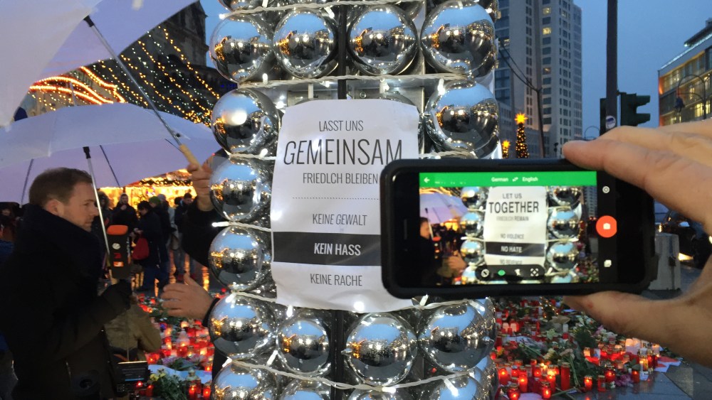 A poster and candles at the crime scene at Breitscheidplatz on the reopening day of the Christmas market