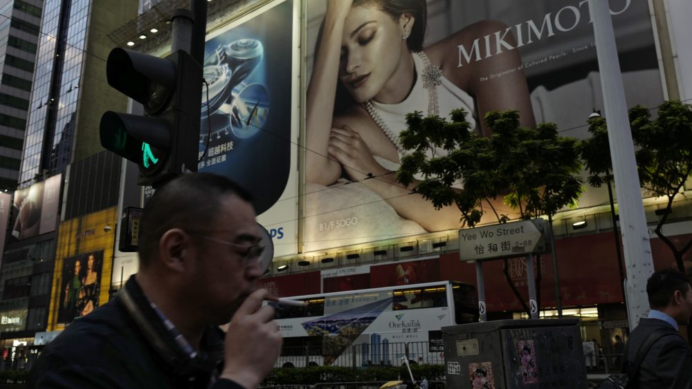 A man walks past an advertising billboard in Causeway Bay in Hong Kong.