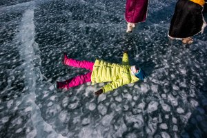 A Mongolian girl lays on the ice at the Lake Khovsgol Ice Festival in Khatgal, Mongolia, on March 3, 2017.