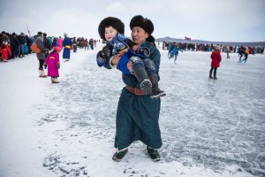 A Mongolian man carries his son at the Lake Khovsgol Ice Festival in Khatgal, Mongolia, on March 3, 2017.