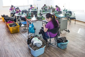Women sew together clothing items at Bodio's of Mongolia in Ulaanbaatar, Mongolia on March 15, 2017. Photographer: Taylor Weidman