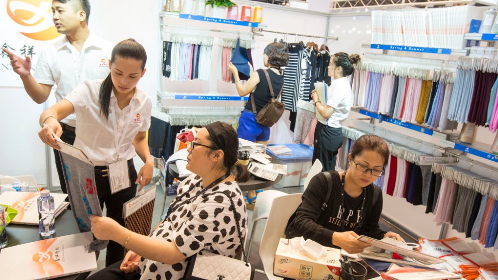 August 29, 2016, Shanghai, China - Vistors examine fabric samples at SPINEXPO fibres, yarn and knitwear trade fair, which was dominated by Chinese exhibitors.