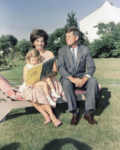 Sen. John F. Kennedy, D-Mass., sits with wife, Jacqueline, as she reads to their daughter, Caroline, at Hyannis Port, MassJFKs Images, Hyannis, USA