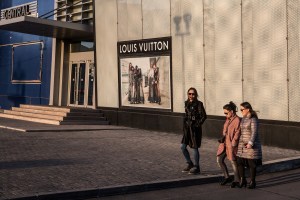 Mongolian women walks past a billboard for Louis Vuitton at Central Tower in Ulaanbaatar, Mongolia on March 19, 2017. Photographer: Taylor Weidman