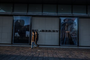 Mongolian men walk past a sign for Burberry at Central Tower in Ulaanbaatar, Mongolia on March 19, 2017. Photographer: Taylor Weidman