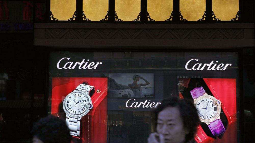 Chinese shoppers walk past a Cartier display in Beijing.