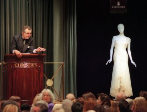 An auctioner for Christie's Auction house takes a bid on the first evening gown from Princess Diana, a wrap-around white silk chiffon evening dress by Gina Fratini, which sold for $75,000, in New York. Proceeds from the most talked-about celebrity auction since Jackie Onassis' heirlooms were up for bids will go to AIDS and cancer charities.