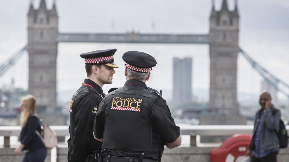 Police watch as people cross London Bridge for the first time after a terrorist attack on Saturday eveningAftermath of London terrorist attack, UK - 05 Jun 2017