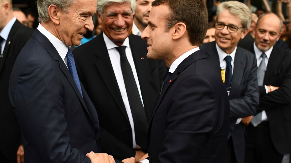 French President Emmanuel Macron, right, shakes hands with LVMH Group CEO Bernard Arnault as he visits the Vivatech, a gadgets show in Paris, France, Thursday, June 15, 2017. French President Emmanuel Macron is shaking hands with robots and encouraging entrepreneurs as he unveils his strategy to transform the country from a land resting on the laurels of its past into a "startup nation." (Martin Bureau/Pool Photo via AP)