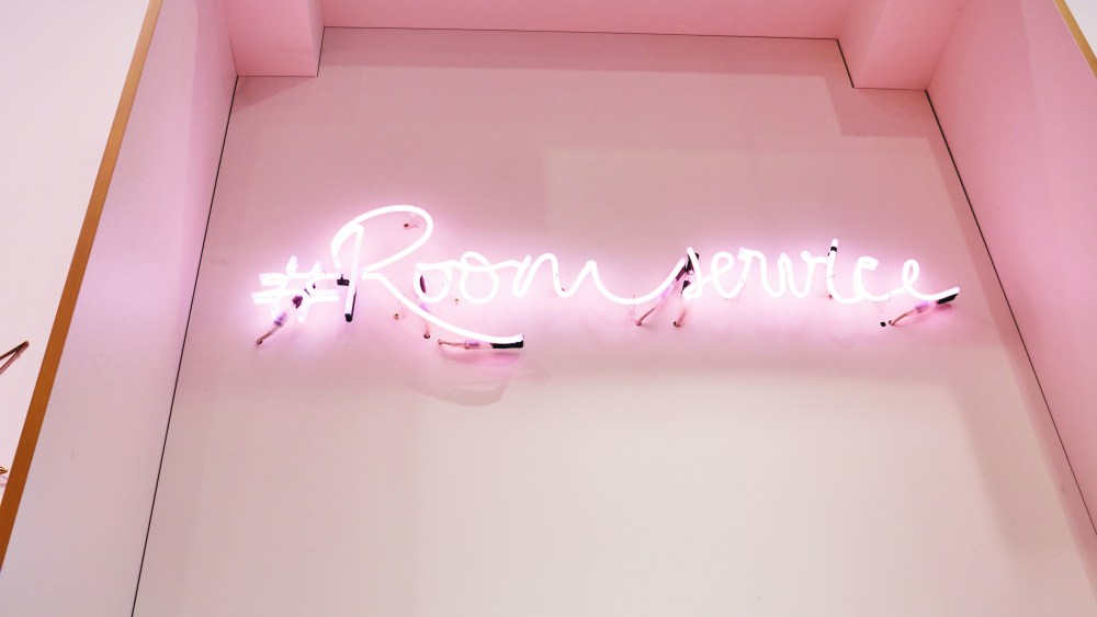 A neon sign in Naf Naf's Room Service pop-up.