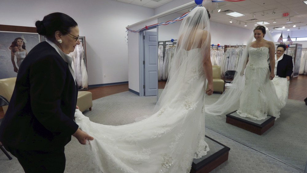 Jo Acchione, Jennifer Dunn Store employee Jo Acchione, left, helps as former Army National Guard member, Jennifer Dunn, tries on a wedding gown at Alfred Angelo Bridal, in Cherry Hill, N.J. The store is offering free wedding dresses to members of the armed services on Veterans Day. The bride to be had to present a valid current military ID or DD214, along with matching government issued photo ID in order to receive the free bridal gownVeterans Day Wedding Dresses, Cherry Hill, USA