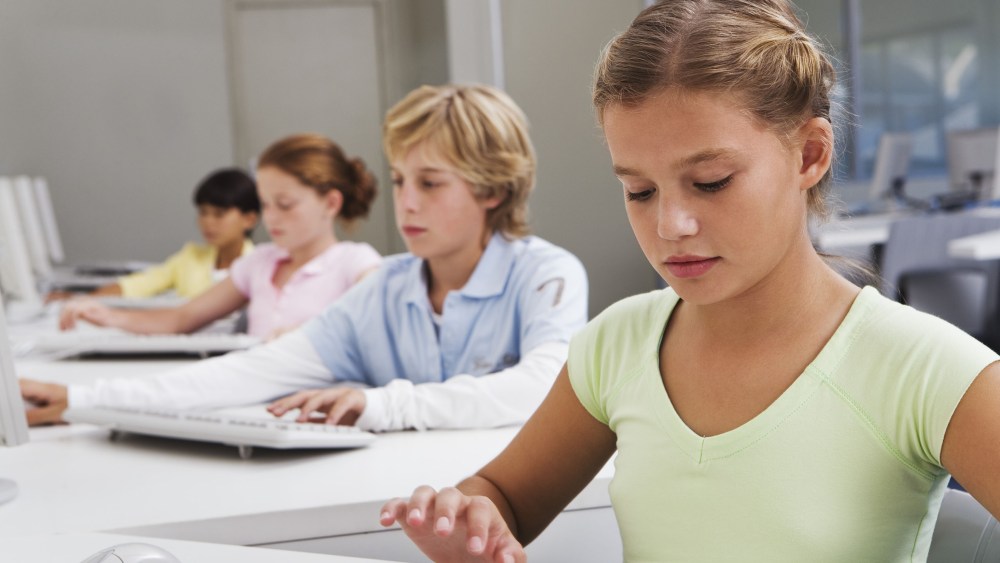 MODEL RELEASED Group of school children (10-13) using computers in classroomVARIOUS