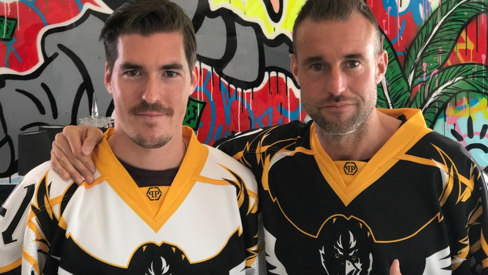 Philipp Plein and Hockey Club Lugano team member Dario Bürgler wearing Plein's jerseys.