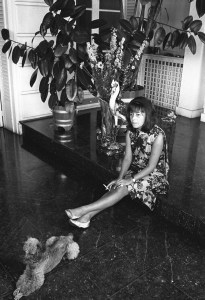 Published; Cropped for publication; Portrait of French actress Jeanne Moreau wearing a loose chemisey dress of orange silk with black scroll print and no make-up during an interview with Women's Wear Daily, accompanied by a bouncing blue-fox color, small poodle named Voyou (gutter-snipe) in Paris, France, circa August 1964.Article title: "La Moreau"
