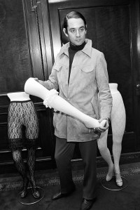 American accessories designer Kenneth Jay Lane holds a bestockinged mannequin leg and is flanked by two more sets of mannequin legs sporting lace tights and garters, 1968.