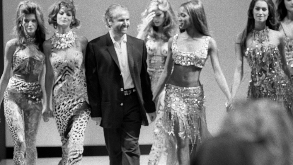 Outtake; Designer Gianni Versace walks down the runway of his Spring 1991 show, holding hands with super models (from left) Stephanie Seymour, Linda Evangelista, Tatjana Patiz, Naomi Campbell and Cindy CrawfordArticle title: "Gianni Shines"