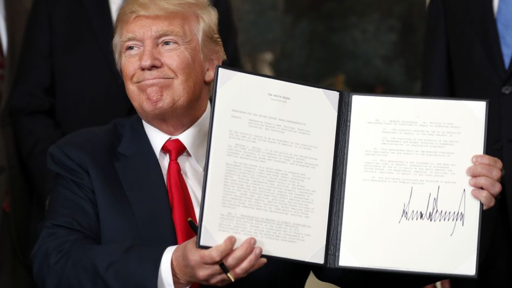 President Donald Trump holds up a signed memorandum calling for a trade investigation of China, in the Diplomatic Reception Room of the White House in WashingtonTrump, Washington, USA - 14 Aug 2017