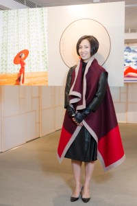 Jiang Qiong Er poses in front of a photograph of by Chen Man.
