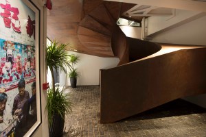 A towering spiral staircase connects every level, which feature floor-to-ceiling glass facades.