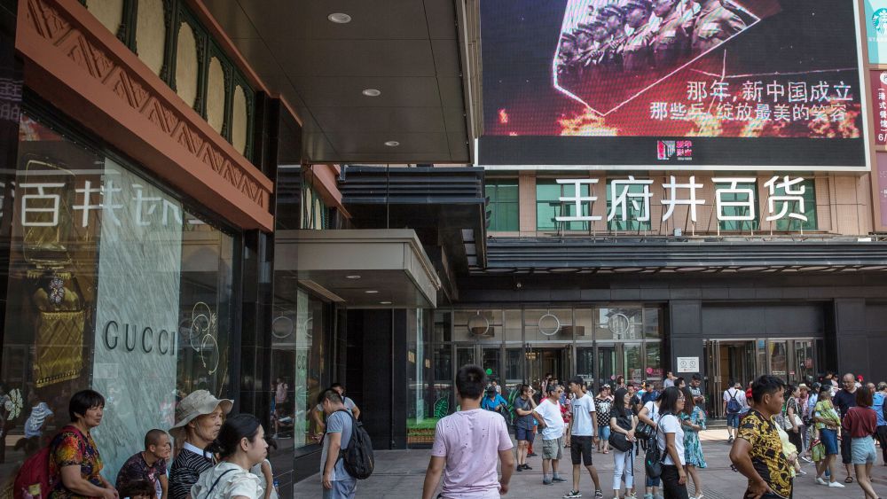 Chinese people walk next to a screen showing Chinese soldiers, at a shopping and tourist district in Beijing, China, 30 July 2017. China will mark the 90th anniversary of the founding of the People's Liberation Army on 01 August 2017.Daily life in Beijing, at 90th anniversary of the founding of the People's Liberation Army, China - 30 Jul 2017