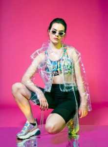 Jeremy Scott’s swimwear lycra bra under Neith Nyer’s polyurethane jacket and Alala’s nylon jersey and perforated nylon shorts. Stella McCartney sneakers and Illesteva sunglasses.