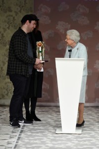 Queen Elizabeth presents Richard Quinn with the award