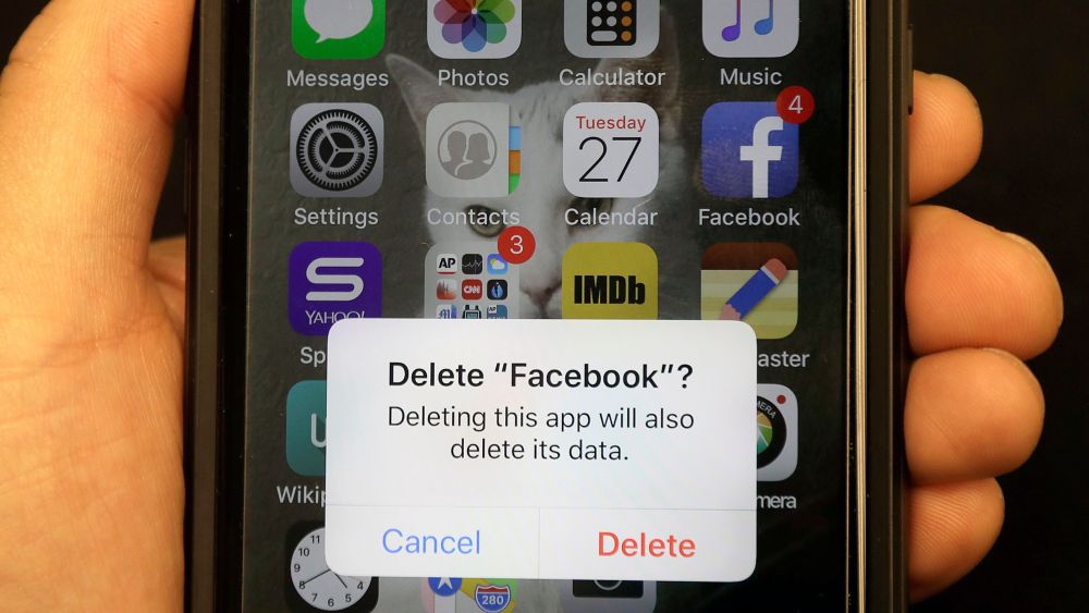 A reporter holds a phone showing the Facebook app in San FranciscoFacebook, San Francisco, USA - 27 Mar 2018