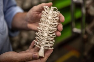 Lars Nelson, Vice President of Pandora’s Lamphun facility, holds a “tree” that has been set with gemstones.