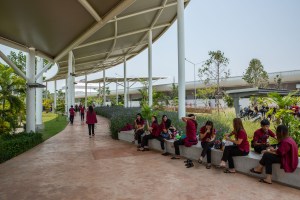 Employees sit in the shade to eat lunch and socialize at the new Pandora facility. The Lumphun facility is shaped like a Pandora bracelet and features a curved roof that covers much of the outside walkways to create shade and protection from the sun.