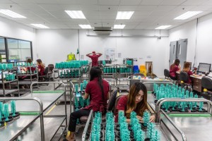A female employee moves wax “trees” set with gemstones onto trays so they can be moved to the next phase of the jewerly making process.