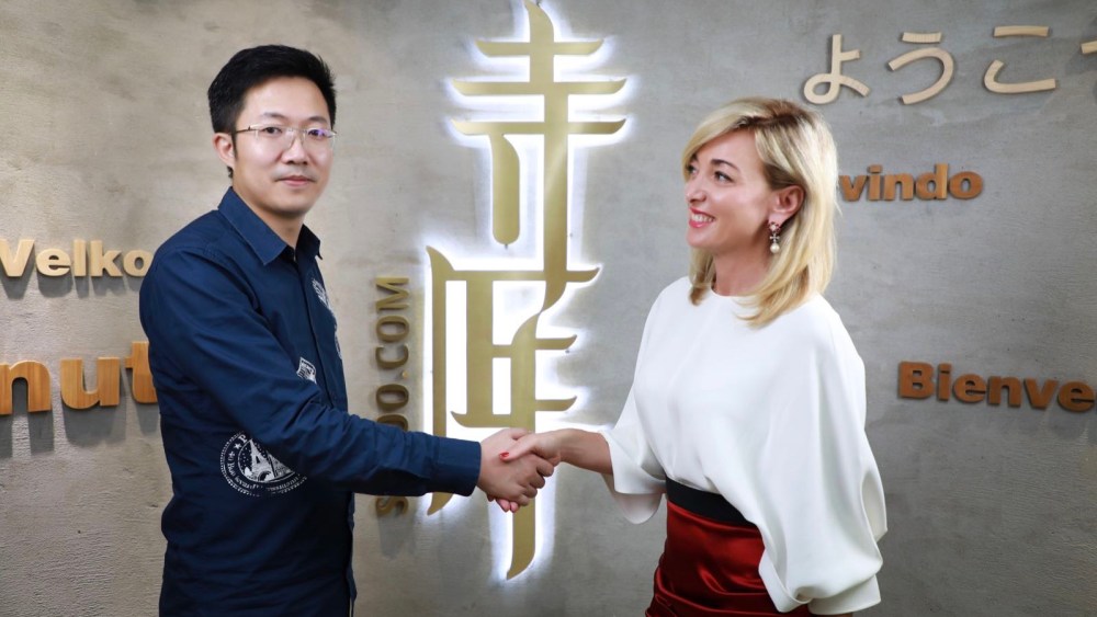 Secoo ceo Richard Li shakes hands with Federica Marchionni, the firm's new executive.