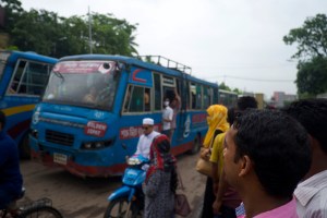 A man looks on at buses carrying garment workers leaving an factory complex in Chittagong, southern Bangladesh.