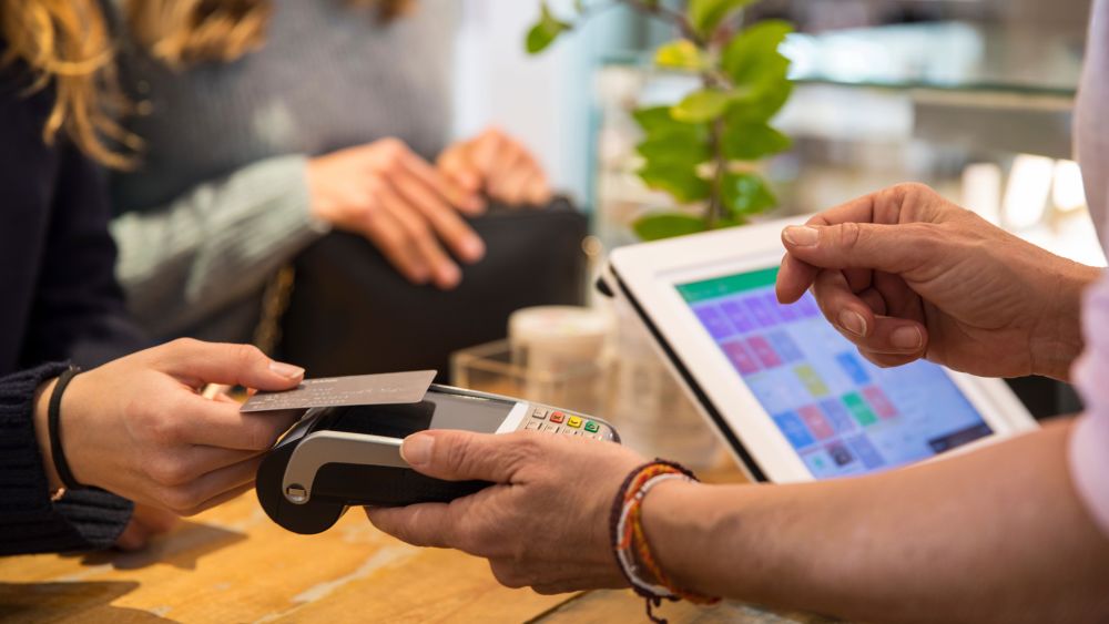 Minimum usage fee is £35Mandatory Credit: Photo by Cultura/REX/Shutterstock (9706678a)MODEL RELEASED, Female customer in shop, paying for goods using credit card on contactless payment machine, mid section, close-upVARIOUS