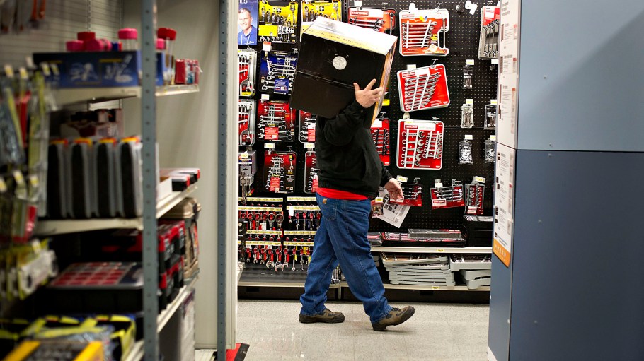 A Black Friday shopper carries an item on his shoulder in a Sears store at Simon Property Group Inc.'s Great Lakes Mall in Mentor, Ohio.