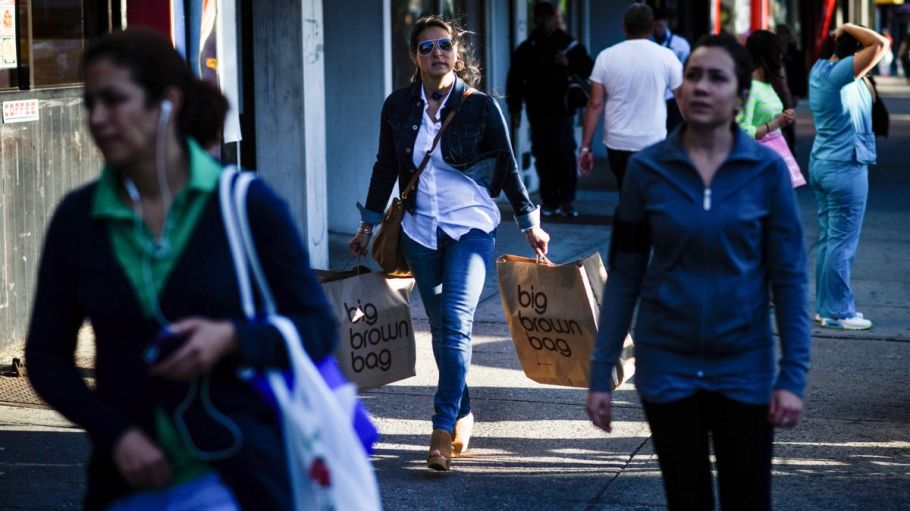 A shopper carries Bloomingdale's Inc. bags while walking on Steinway Street in the Queens borough of New York, U.S.