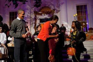 President Barack Obama and First Lady Michelle Obama hand out Halloween treats to children on the North Portico of the White House.
