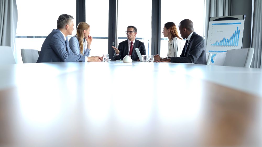 MODEL RELEASED Multi-ethnic business people having discussion at table in board roomVARIOUS