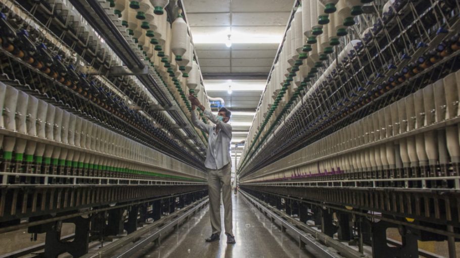 An employee monitors ring spinning machinery in the spinning unit at the Artistic Denim Mills Ltd
