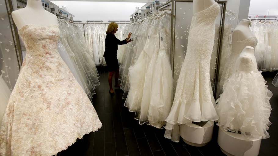 A store manager looks for gowns for customers to try on at a David's Bridal